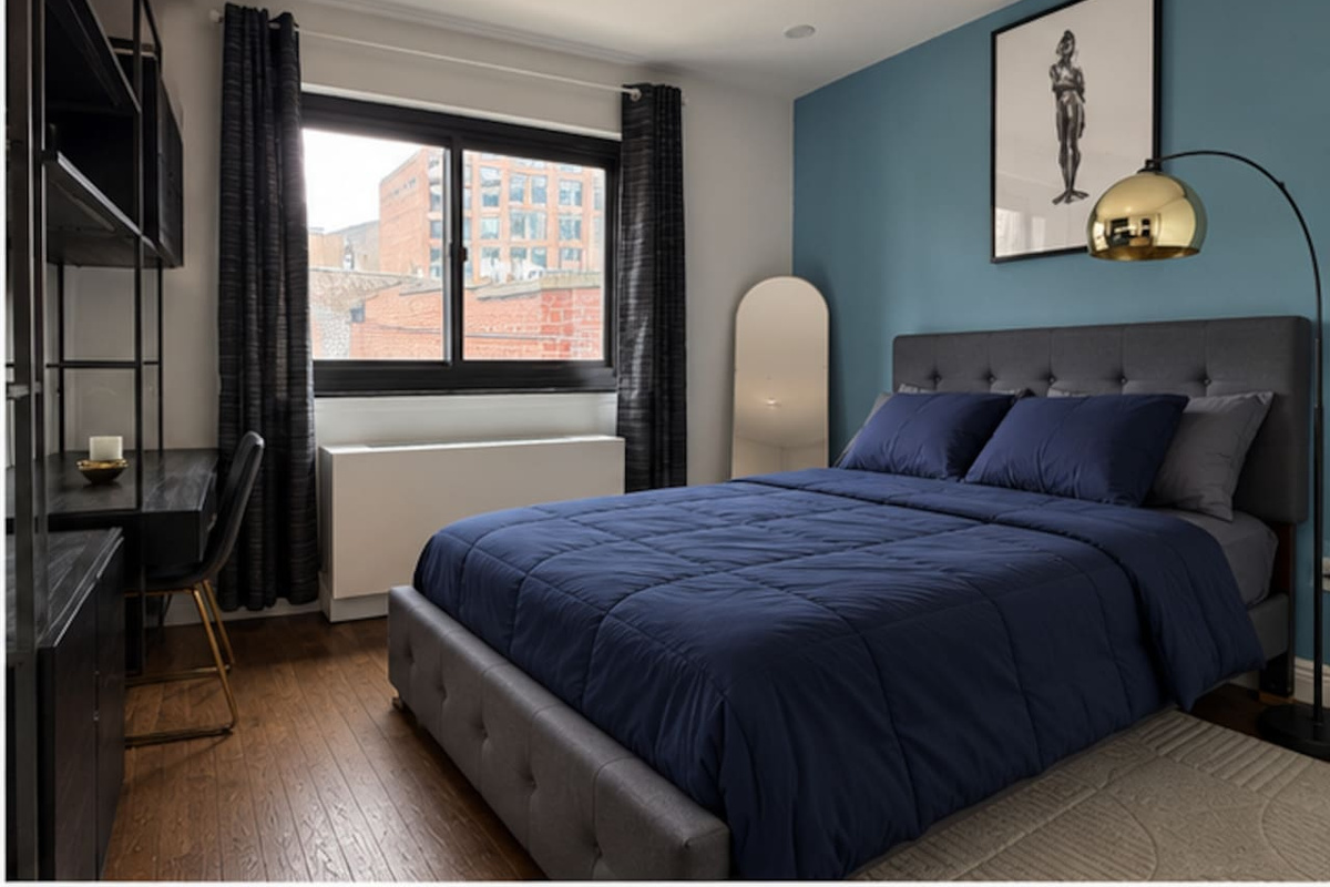 Spacious primary bedroom with city views — Little Italy NYC 2-bedroom apartment rental.