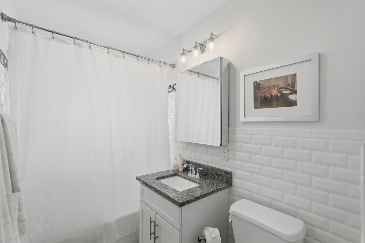 Conveniently located for guests, the second full bathroom offers a bathtub, fresh towels, and everything you need to get ready for a day of beach adventures.