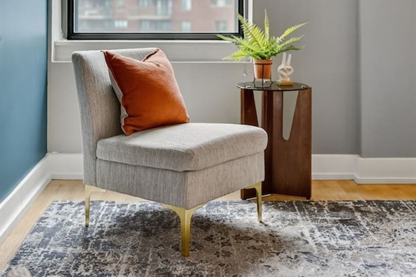 Curl up in the cozy lounge chair by the window, complete with a bright accent pillow and leafy greenery. Natural light and city views make this corner a peaceful escape for morning coffee or evening reading.