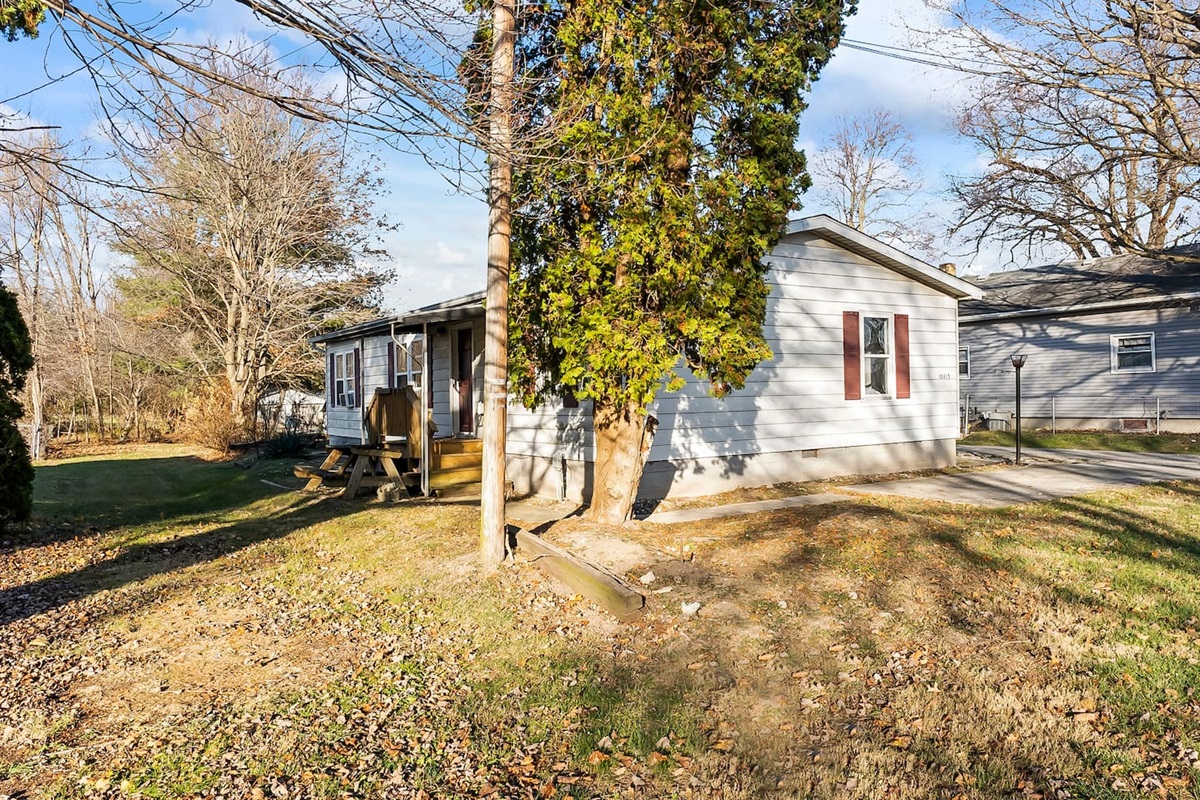 Charming exterior with a small porch and picnic table area for outdoor enjoyment.