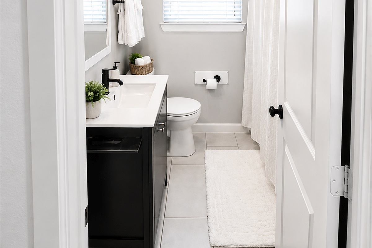 Clean and airy full bathroom with soaking tub, modern vanity, and fresh boutique-hotel aesthetic