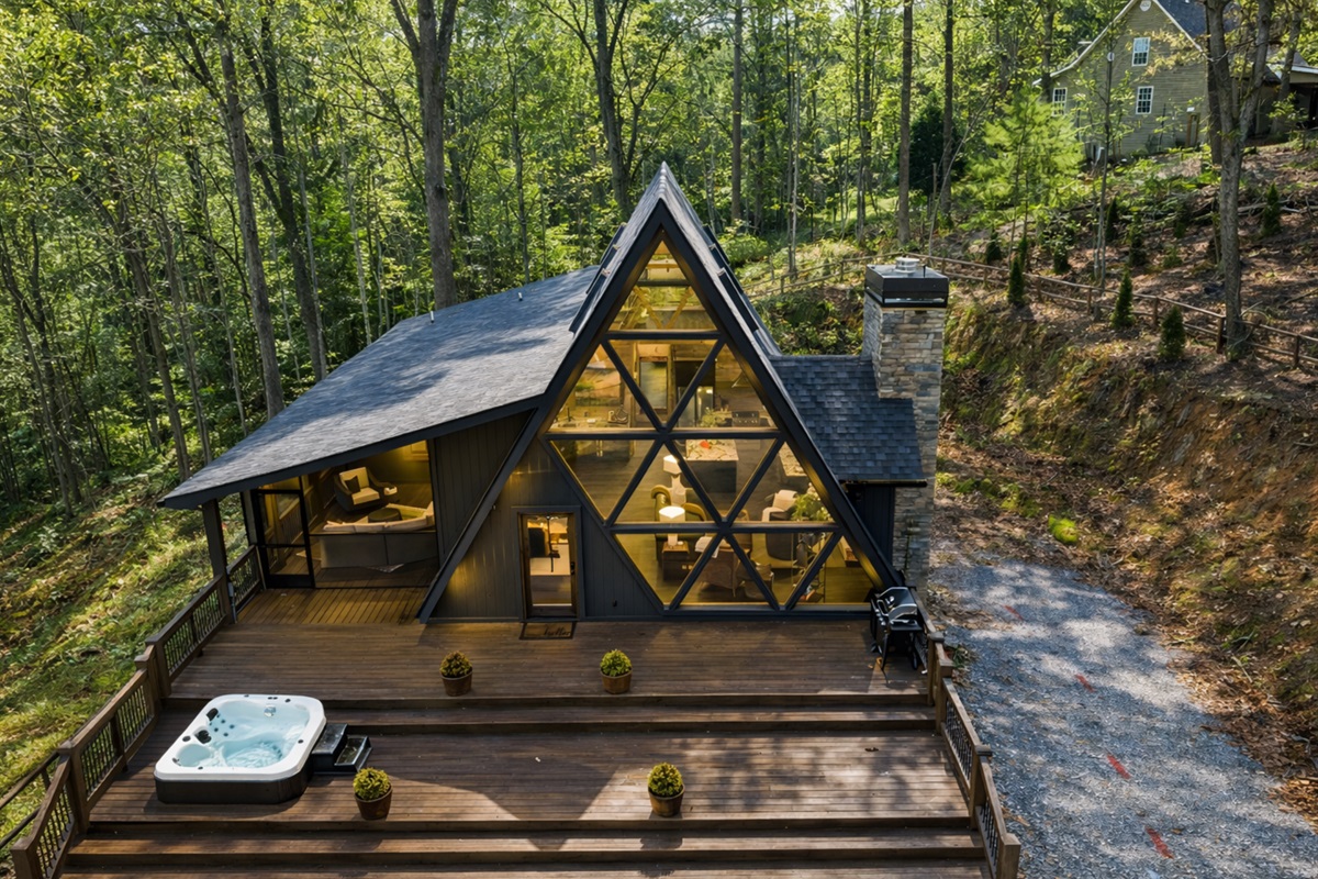 A modern A-frame retreat wrapped in nature, soaring windows, warm light, and peaceful mountain surroundings.