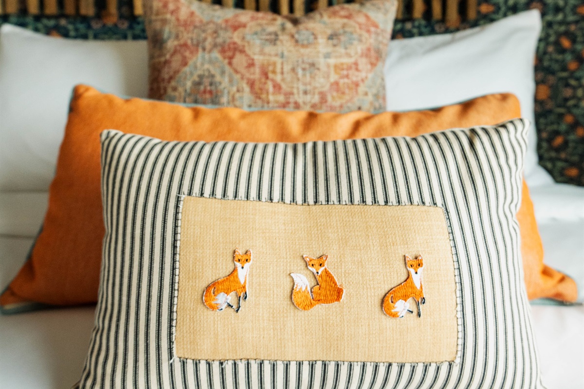  Curated textile detail at the Corral Suite — handcrafted accent pillows layered over premium Comphy linens at Gaines Ranch on the Square.