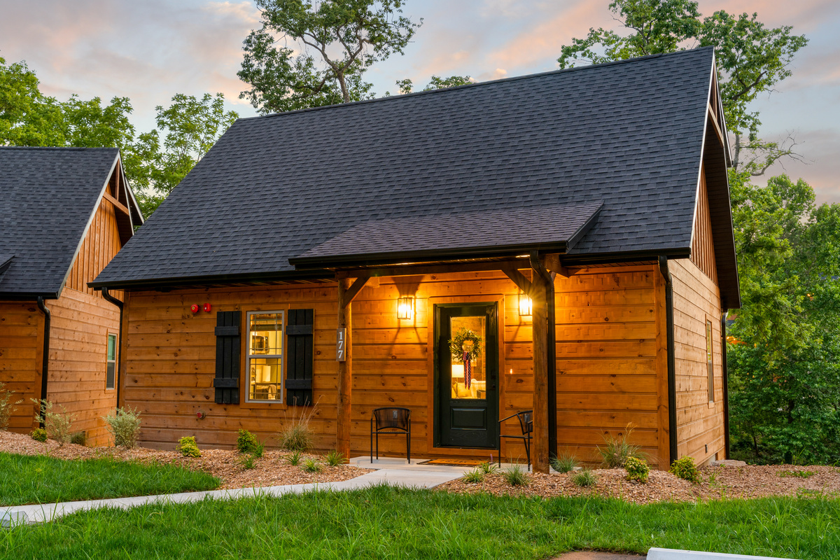 Pull up to a warm porch glow and a classic green door that says you have arrived.