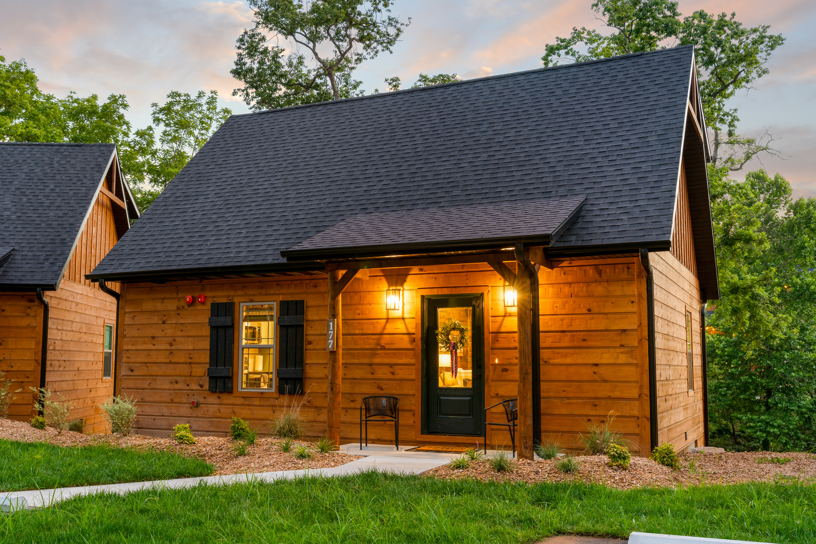 Pull up to a warm porch glow and a classic green door that says you have arrived.