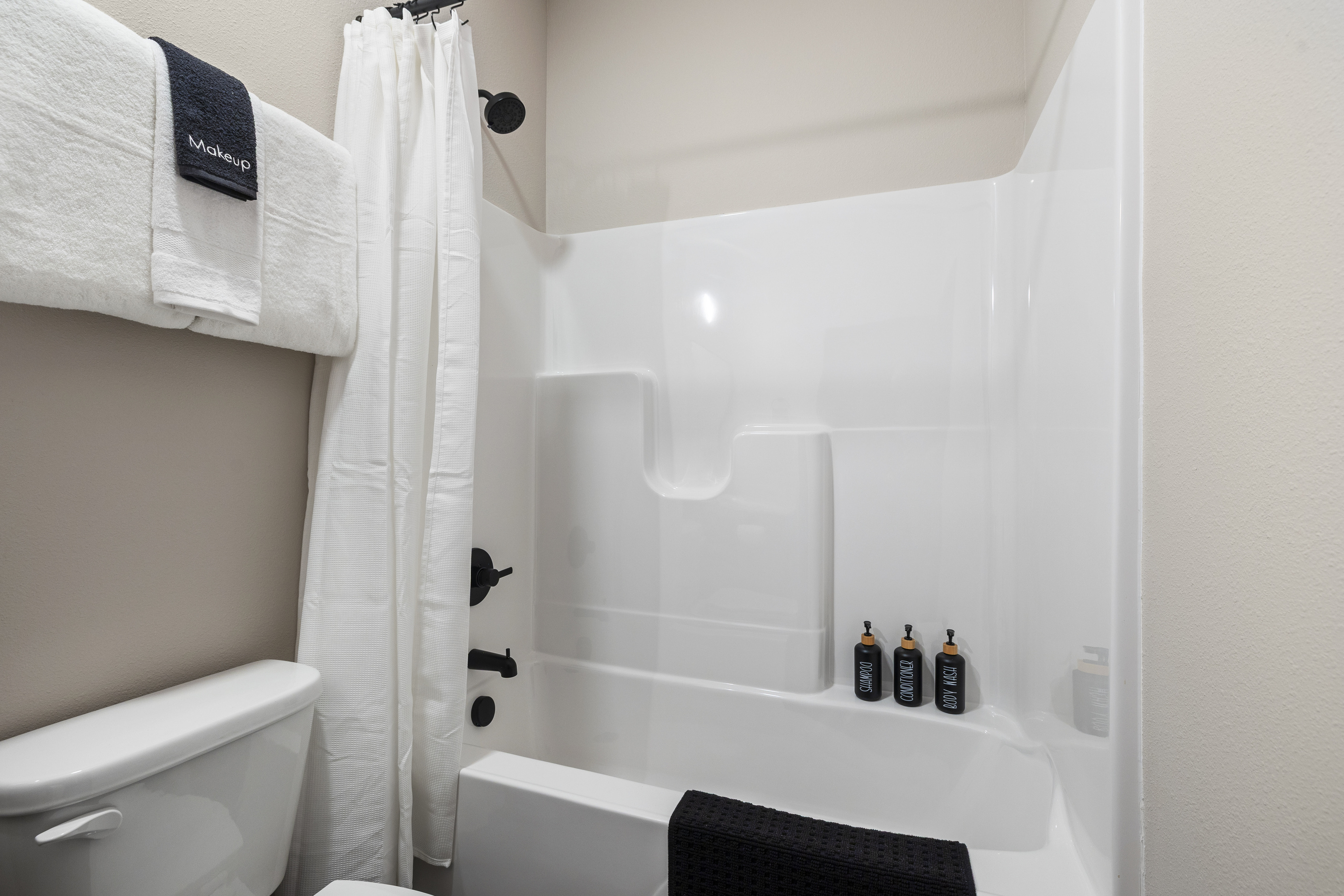 Walk-in shower, wood vanity, and a lit mirror in the ensuite.