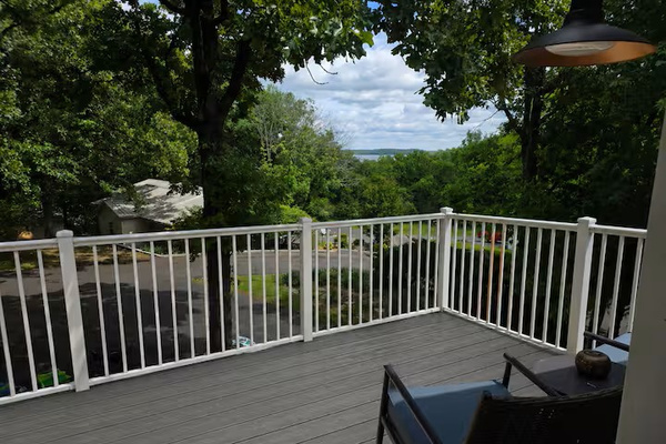 Upper-level deck with peaceful lake views, outdoor seating and a relaxing spot to enjoy the wooded setting.