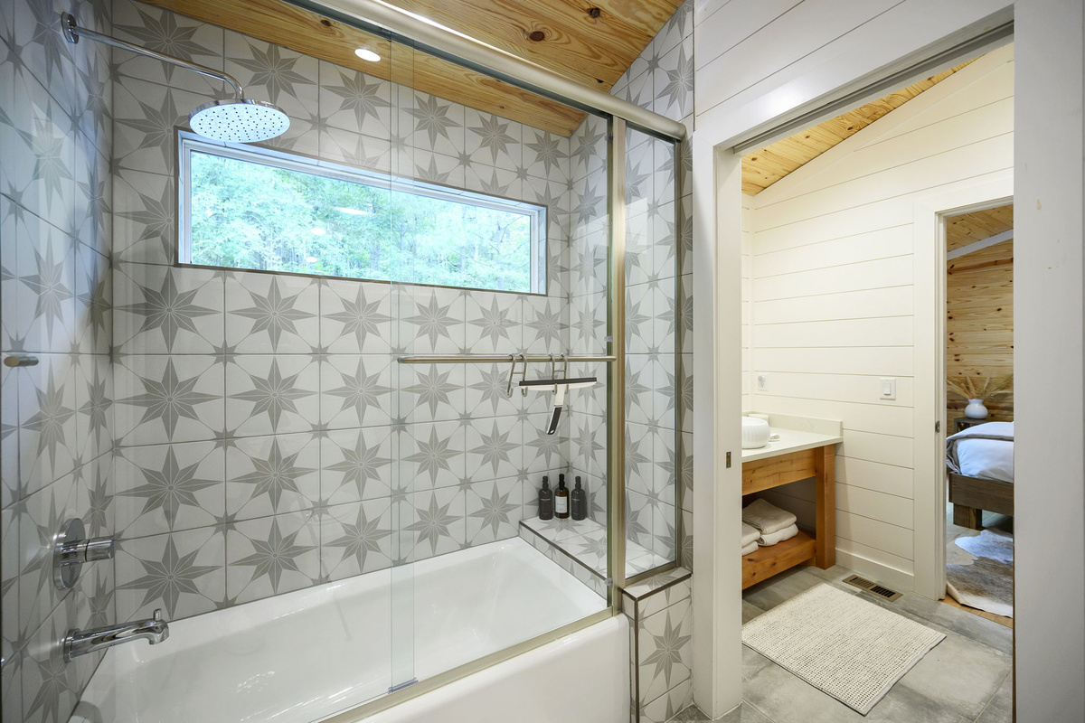 The shared full bathroom offers a cozy, spa-like feel with luxury finishes, warm design details, and everything guests need to feel comfortable and refreshed.