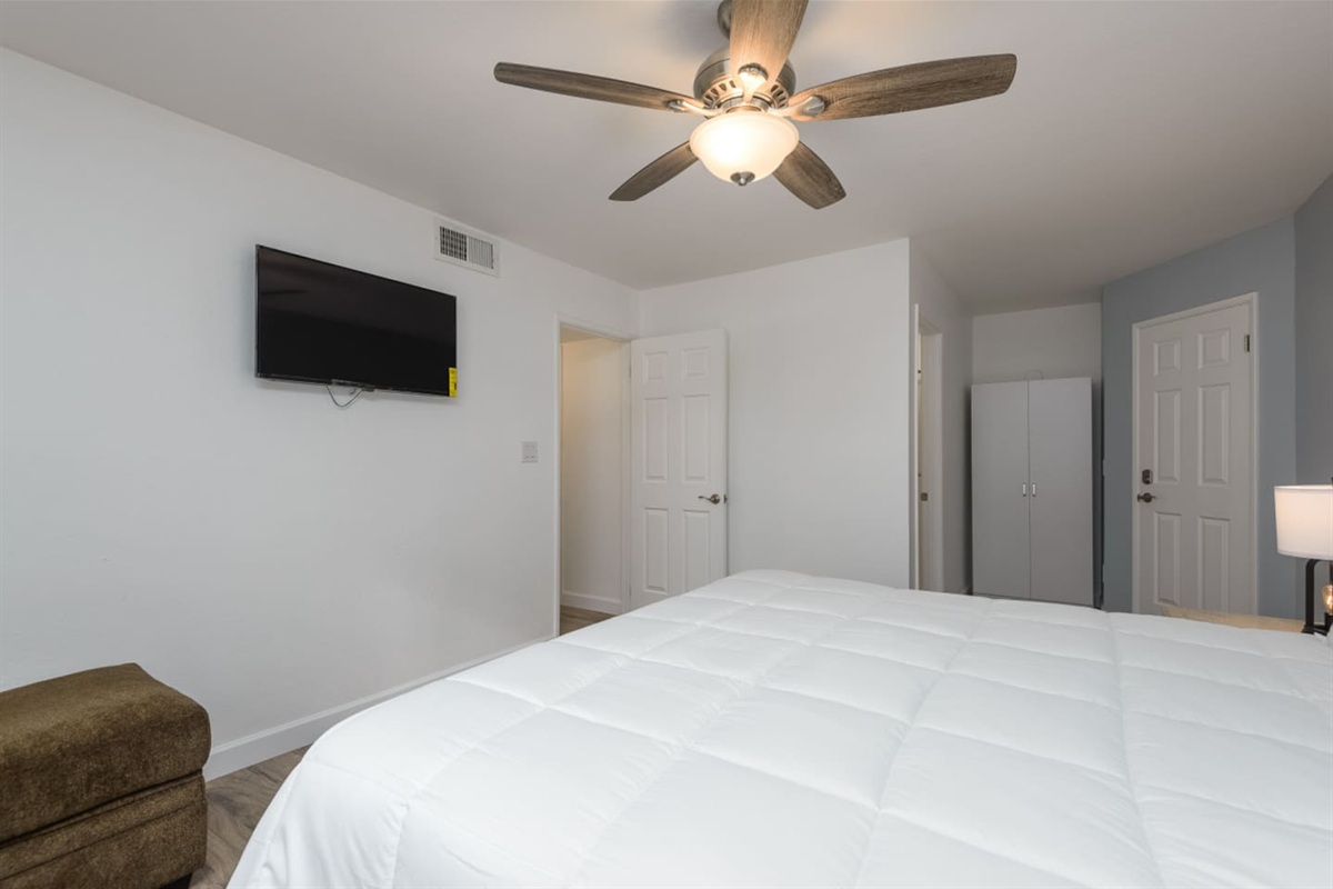 King bedroom with soft bedding, bedside lamps, and a simple place to relax at the end of the day.
