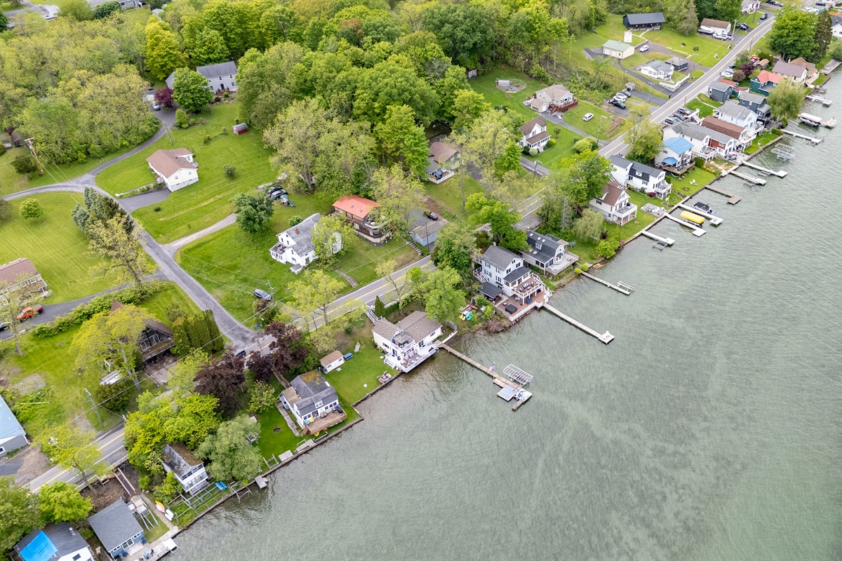 Aerial shot showcasing expansive lakefront entertaining space, hot tub, and private dock for the ultimate getaway 🎯🌊🍹