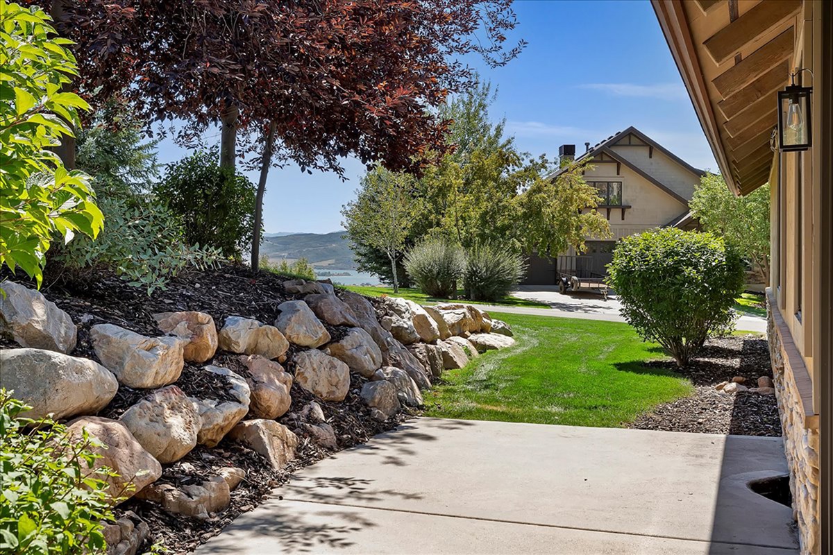Beautiful landscaping and natural stone accents create a serene outdoor setting.