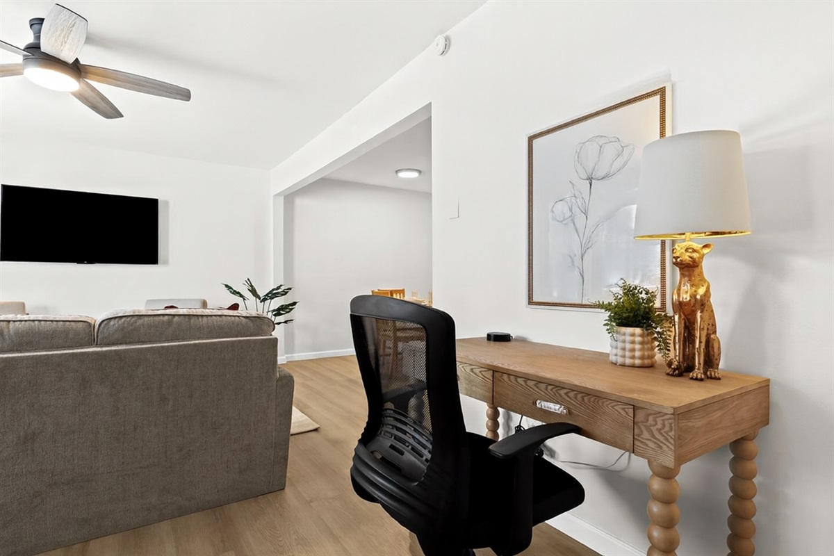 Chic and functional workspace with a rivet-trimmed desk, mesh chair, and cozy lamp—ideal for productivity.