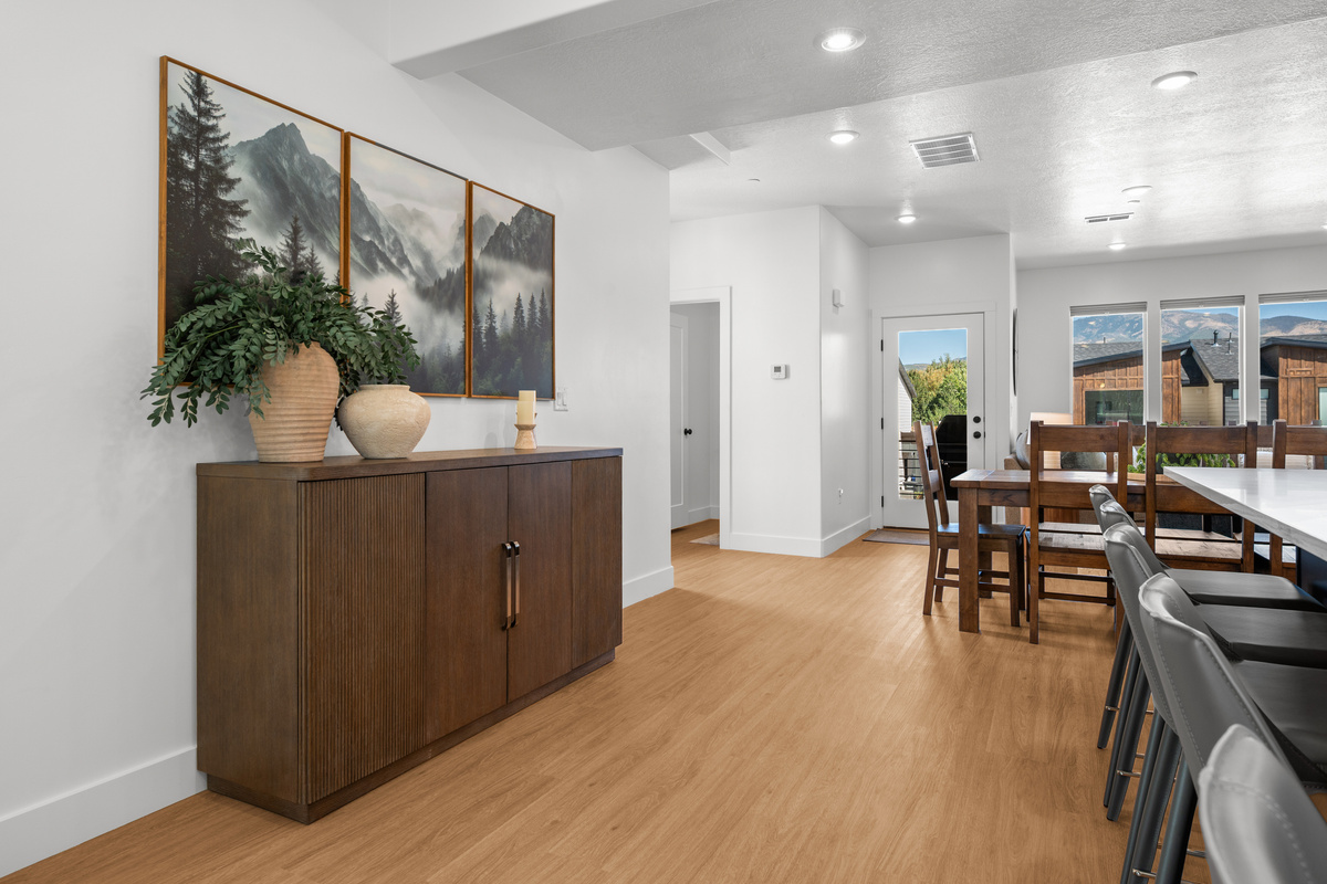 Warm wood accents and thoughtful décor create a welcoming transition through the home’s bright, modern interior.