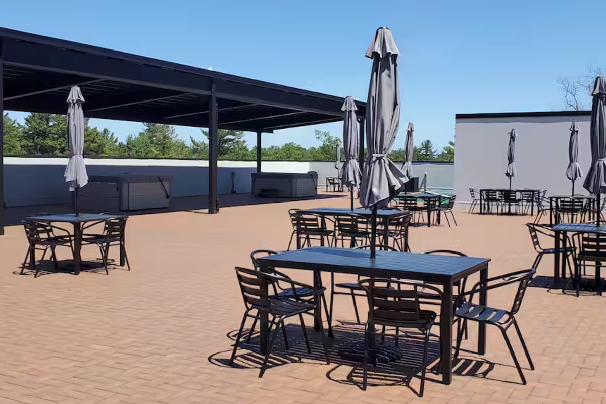 A sun-soaked rooftop retreat with open space to relax, dine, and unwind—featuring shaded lounge areas, cozy seating, and a calm, airy atmosphere perfect for enjoying fresh air and quiet moments.