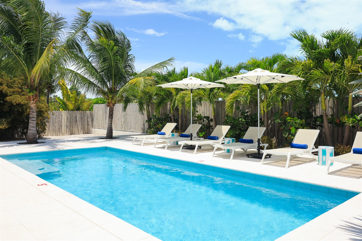 Comfortable loungers with umbrellas by the pool