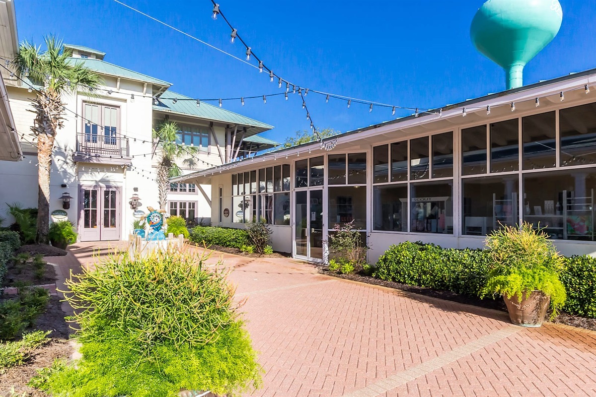 The vibrant heart of The Beach Club Resort entrance: The Village Square. Discover a delightful array of restaurants, amenities, and stores, all conveniently located to enhance your stay.