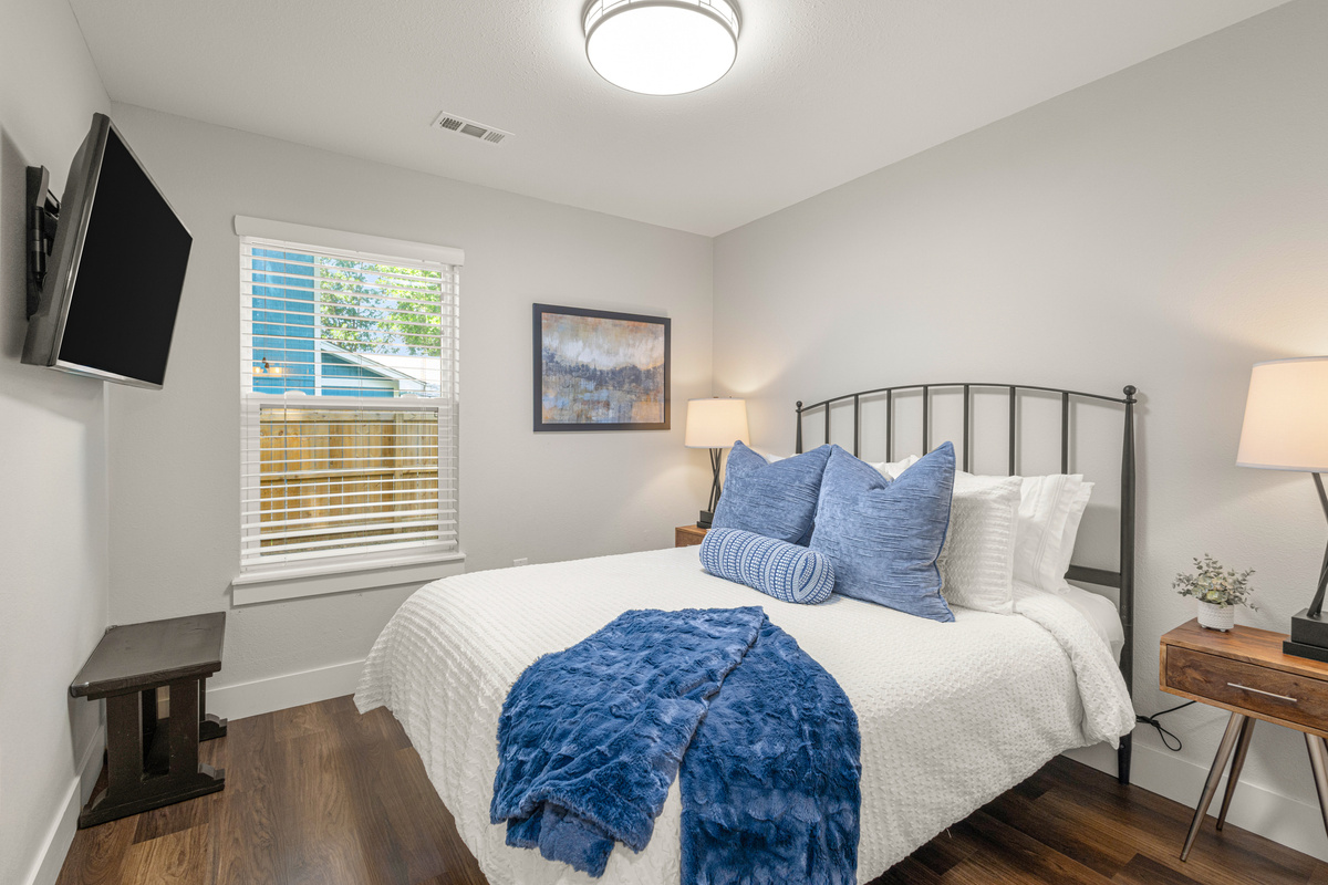 Queen bedroom with mounted TV