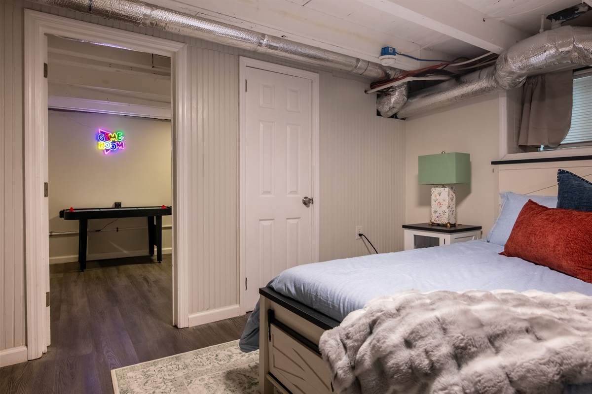 A roomy bedroom with extra floor space, fresh linens, and direct access to the game area