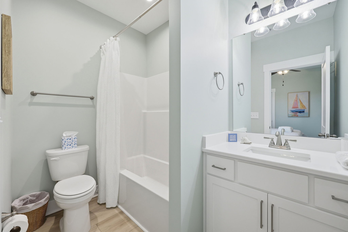 The private en-suite bathroom features a tub and shower combination, making it easy to refresh after a day at the beach