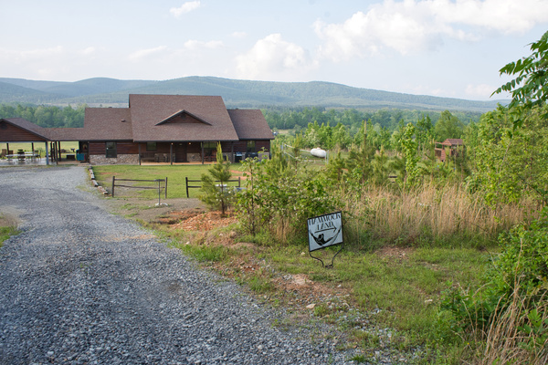 View of the cabin, gravel drive, mountain backdrop, and access toward Hammock Land.
