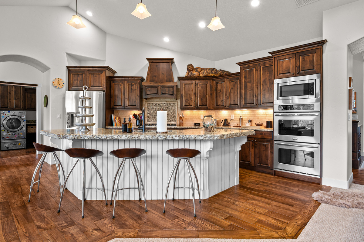 Chef's Kitchen with Seating for Four – Gather around the oversized granite island with bar seating, surrounded by premium appliances, abundant cabinetry, and plenty of space for preparing memorable family meals.