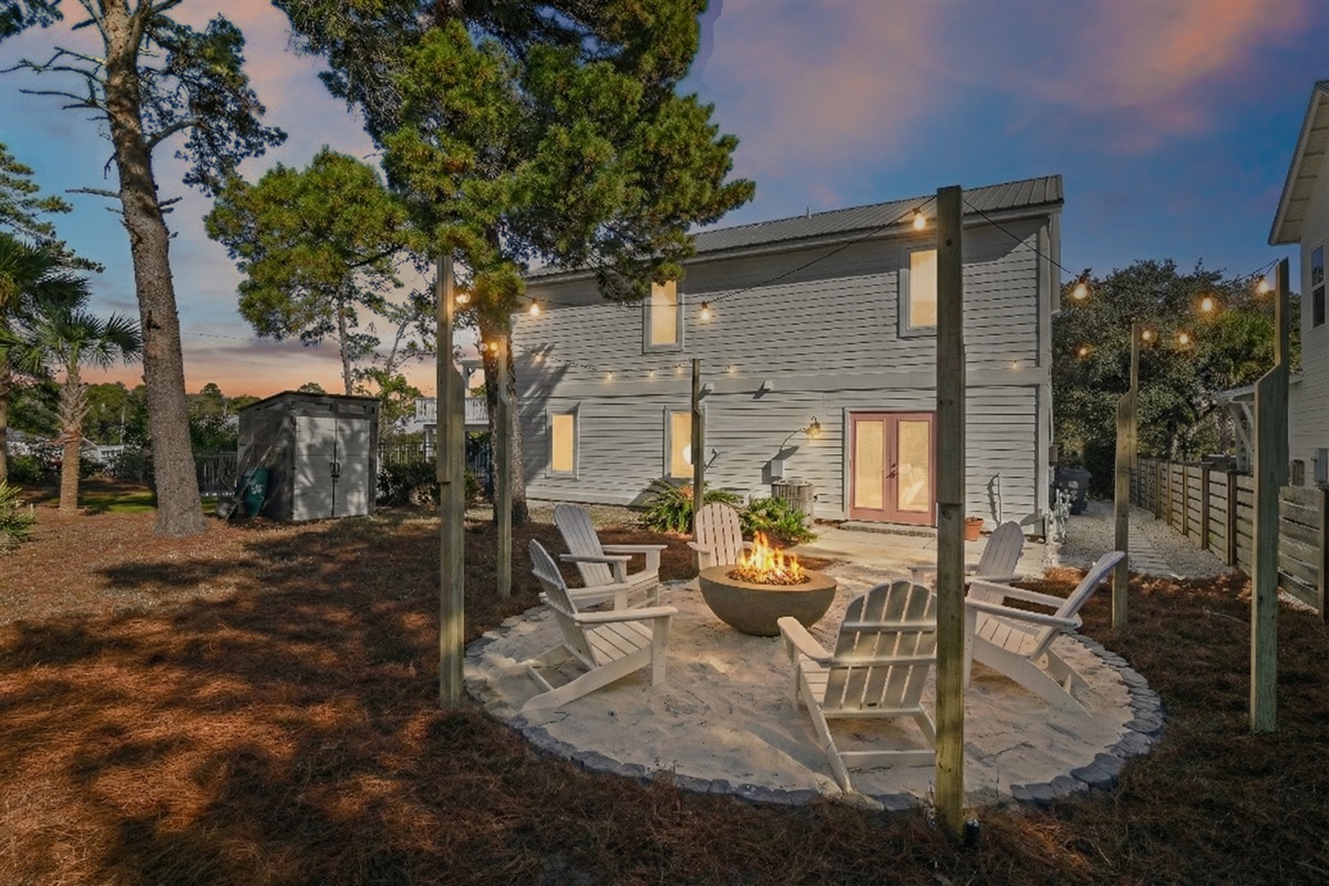 Private backyard fire pit with caf&eacute;-style string lights