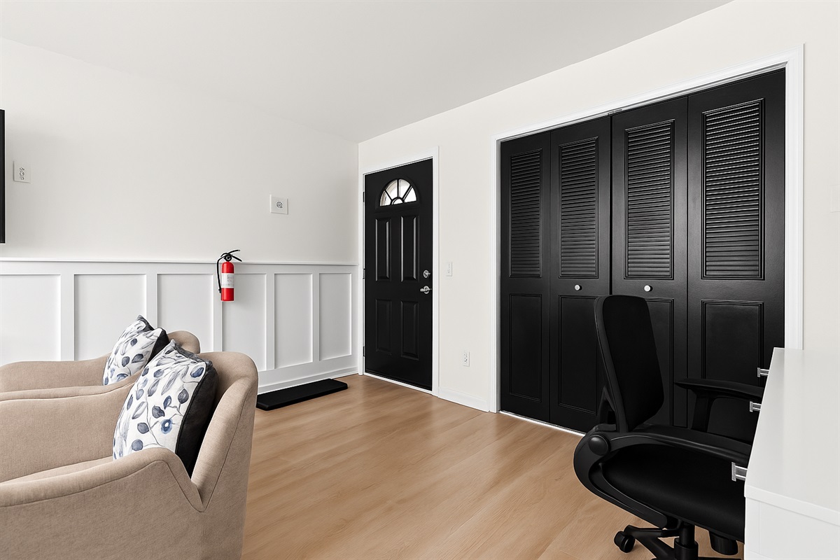 A seamless flow from living room to entryway, featuring bold accents and bright natural light.