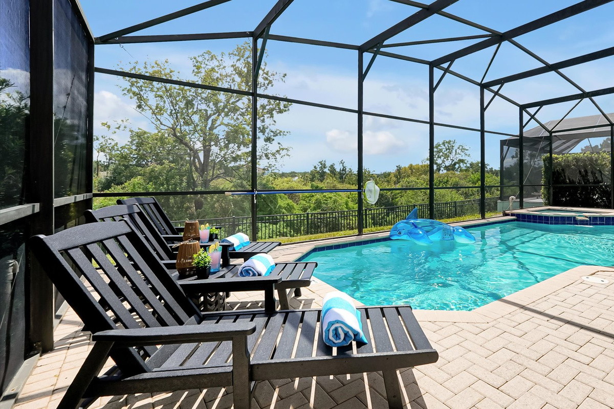 Poolside Loungers: Comfortable loungers overlook the private screened pool, spa and peaceful conservation.