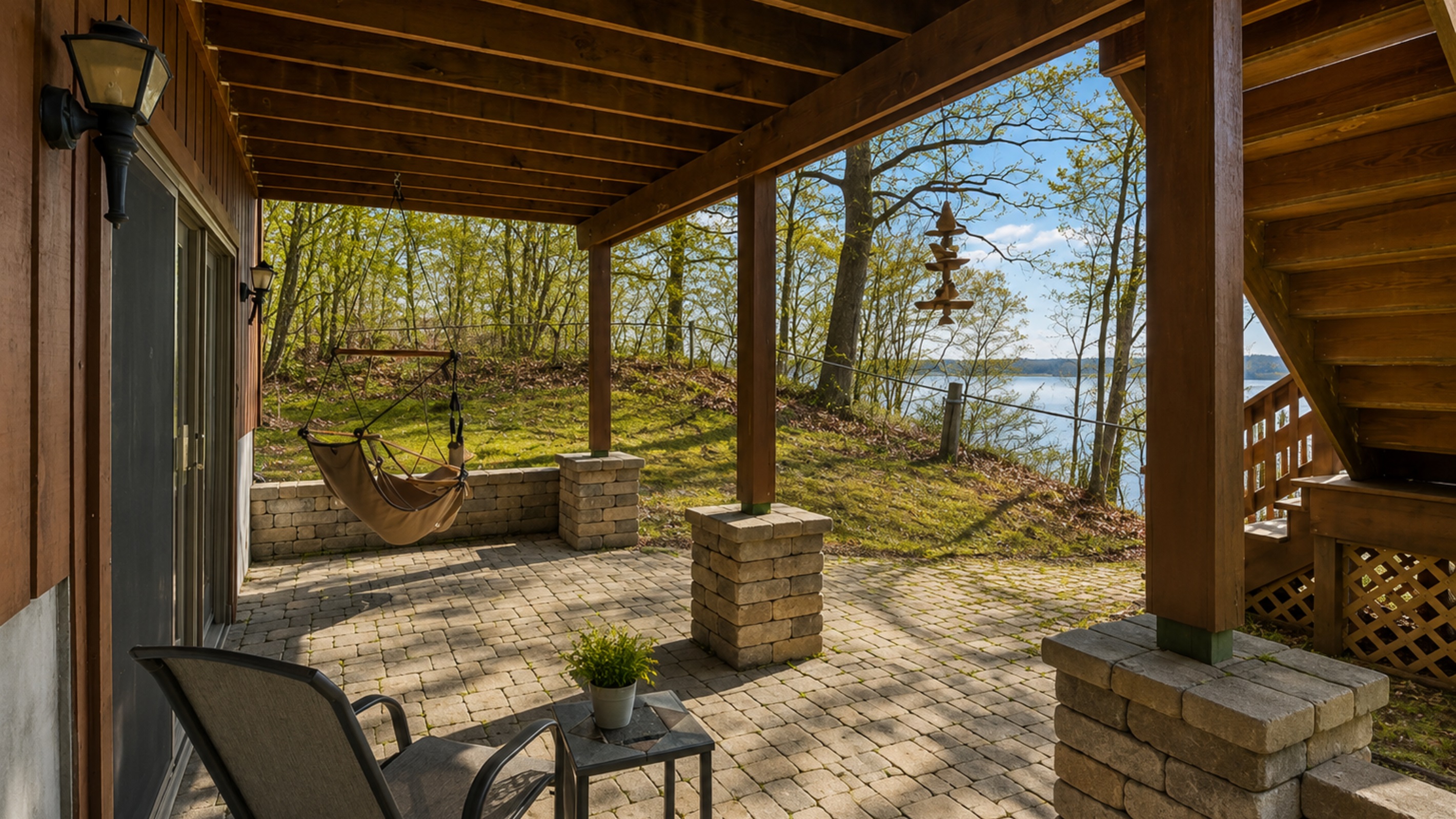 Porch 2 (directly outside of bedroom 4 on the first floor) - Unwind in this sheltered patio area, complete with a hammock and seating, nestled among the trees with a view of the lake. Ideal for tranquil relaxation. 
