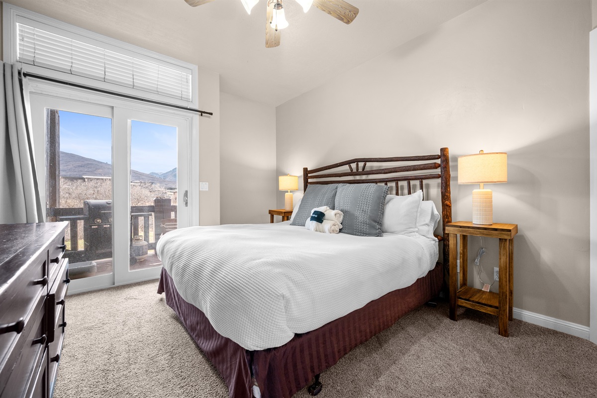 The primary bedroom suite boasts a luxurious king-sized bed, an ensuite bathroom, and deck access!