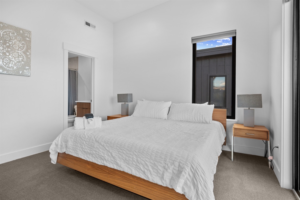 Bright king bedroom with private en-suite bath and modern furnishings.
