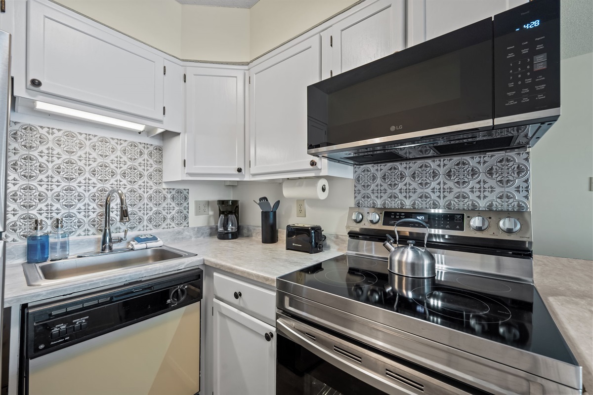 Well-appointed kitchen corner featuring modern appliances, ample counter space, and stylish tile details