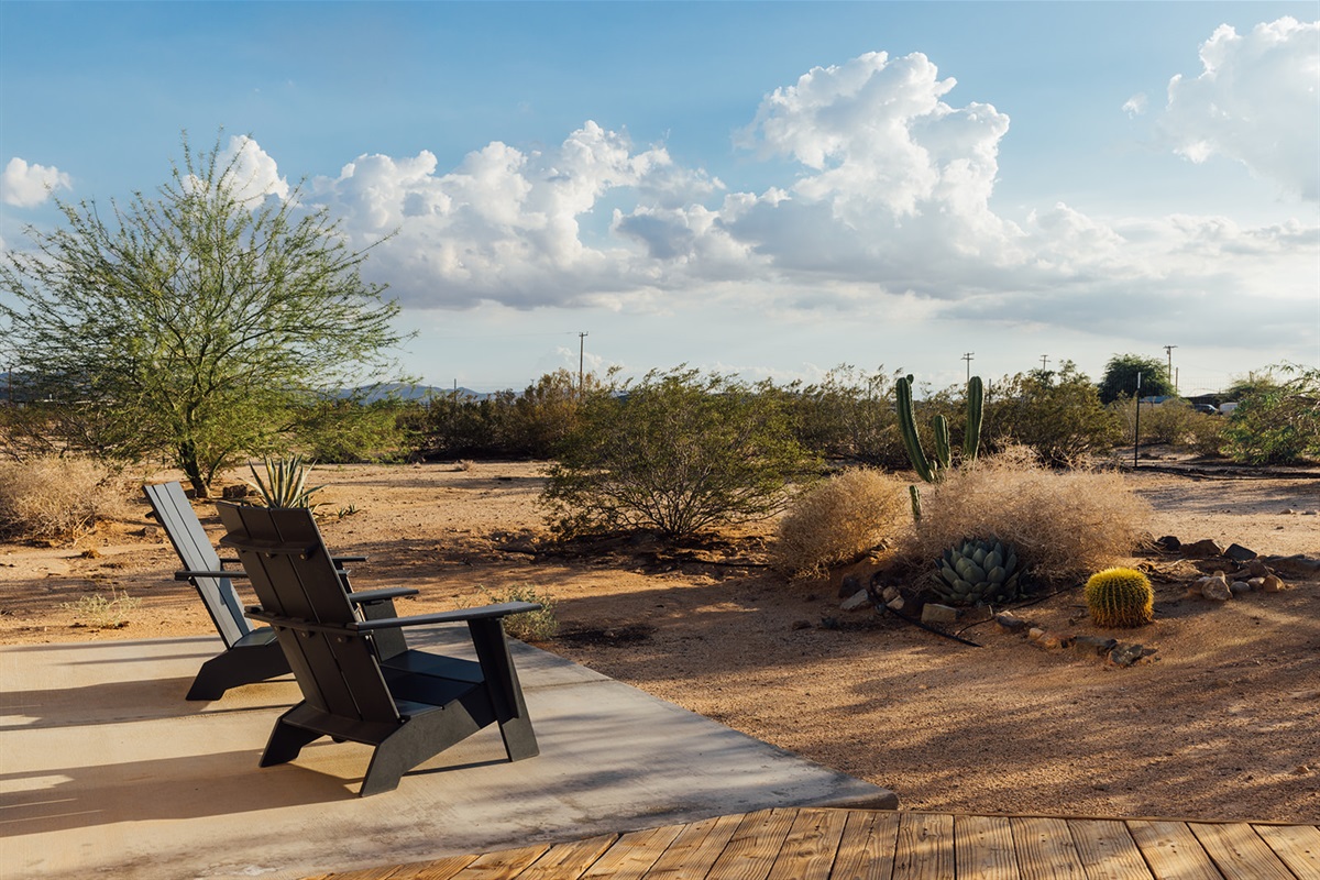 Peaceful desert seating area with two chairs facing open skies — the perfect spot for morning coffee or stargazing