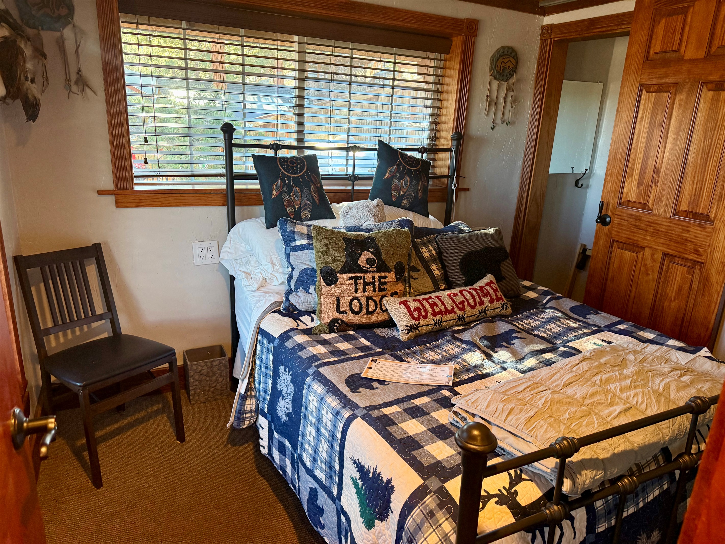 The Dreamcatcher Room - Cozy lodge‑themed bedroom with a full‑size bed, warm wood accents, and mountain‑inspired décor.