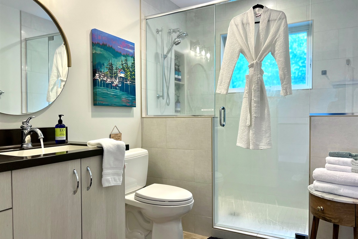 Spacious and spa-inspired, the upstairs shared bathroom features a custom tile, double-headed shower.  Enjoy ample counter space, fresh towels, and plenty of natural light.  What a treat!