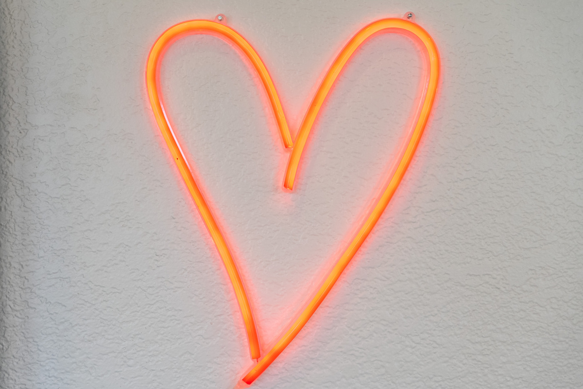 A glowing neon heart adds warmth and character to the space.