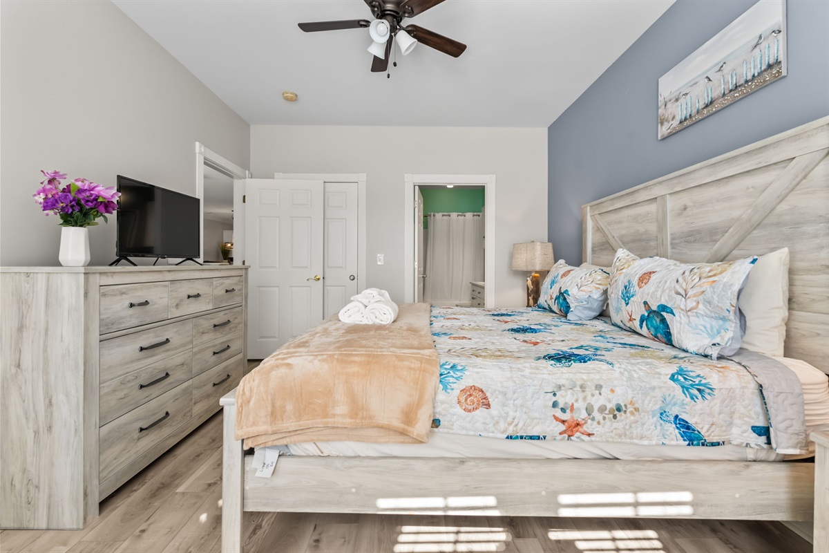 A spacious master bedroom with a flat-screen TV, cozy bedding, and stylish decor—creating the perfect blend of comfort and elegance for a restful retreat