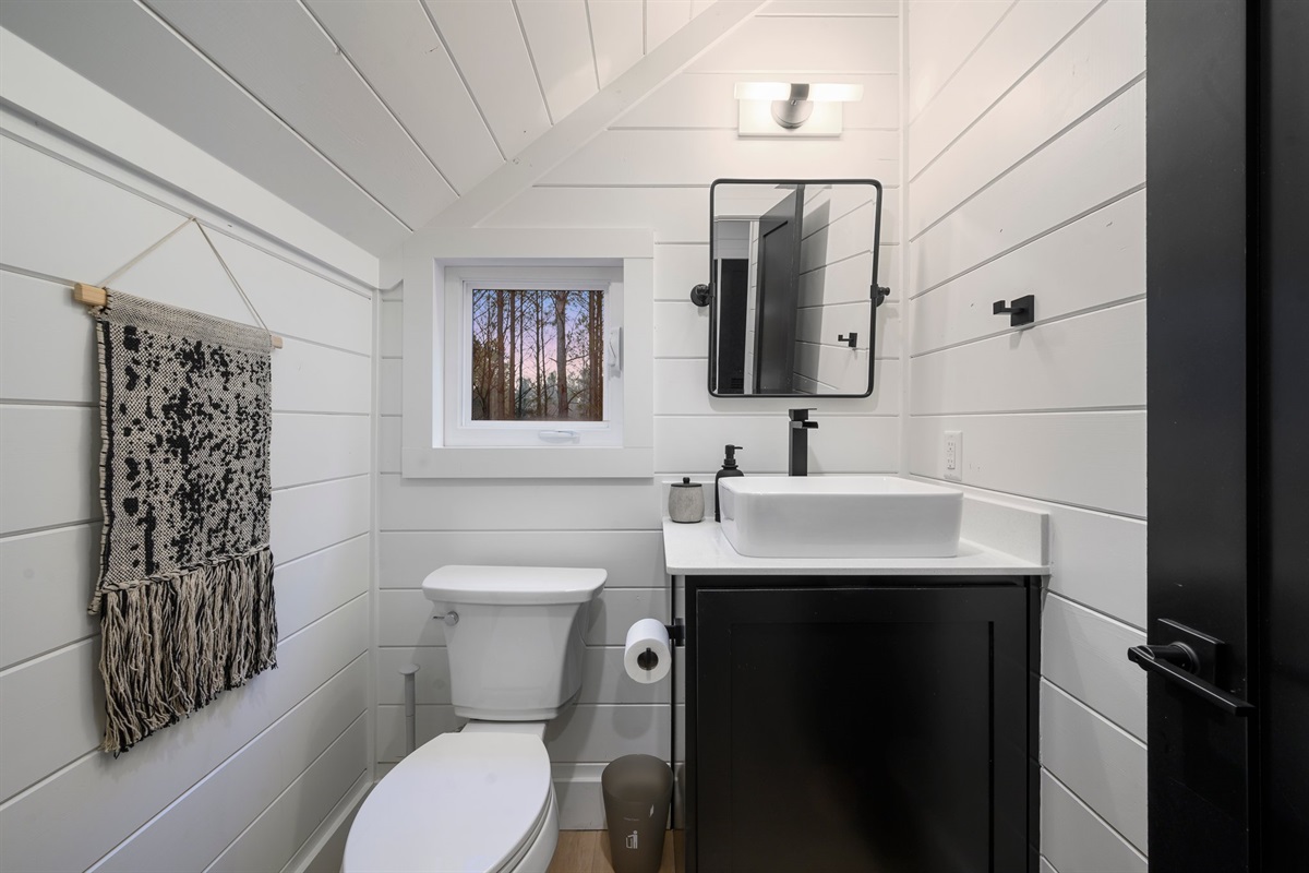 Compact yet beautifully appointed, this guest bathroom blends modern design with cozy cabin charm.