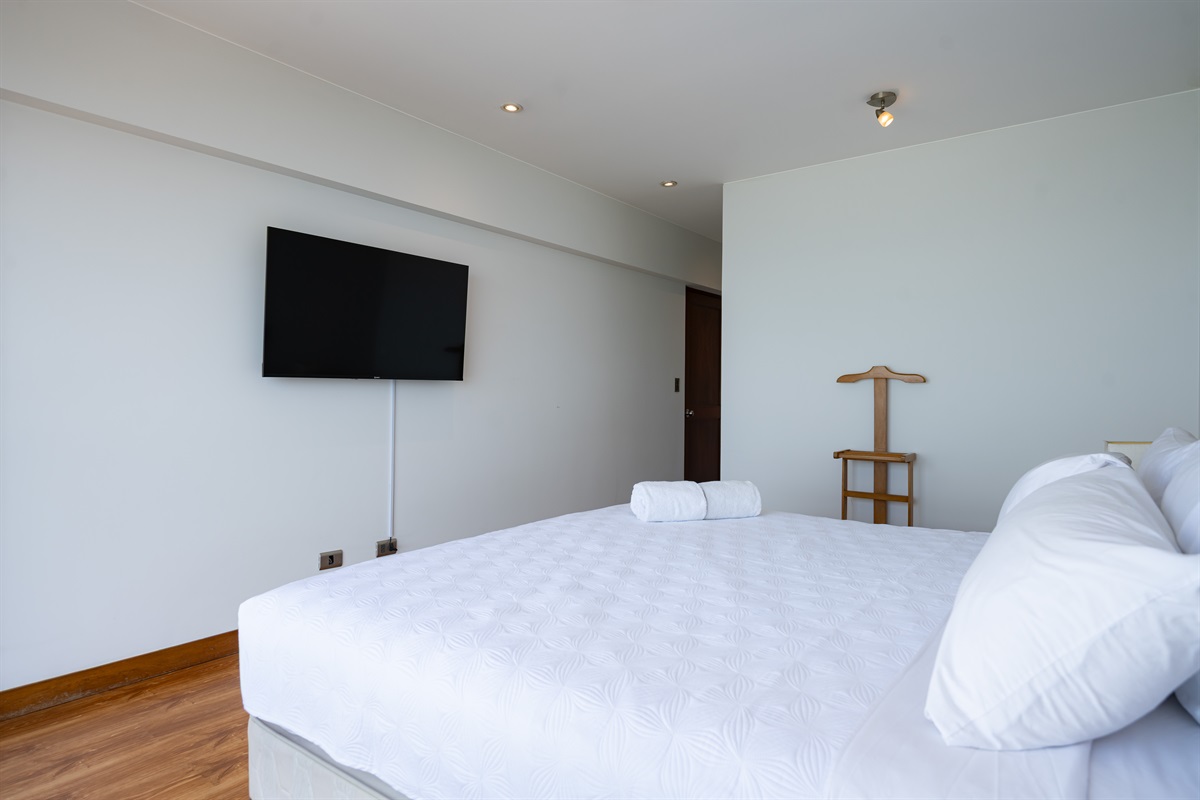Master bedroom with king-size bed, 55” Smart TV, and private en-suite bathroom  /  Dormitorio principal con cama king-size, Smart TV de 55” y baño privado