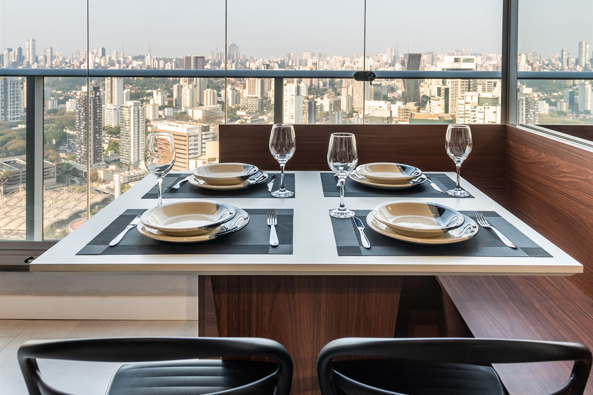 Mesa posta com vista 🥂 Mesa posta para quatro pessoas, Wi-Fi rápido e ar-condicionado. Perfeito para refeições em família ou entre amigos, com skyline incrível ao fundo.