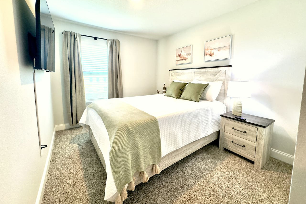 Crisp white linens, a cozy throw at your feet. Sheer curtains glow with soft daylight. Calm, quiet, ready to let go.