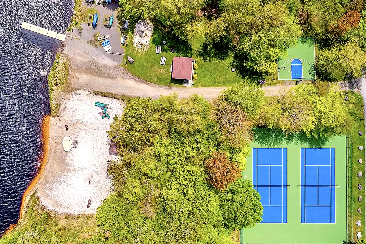 “Bird’s-eye view of Larsen Beach — tennis, sand, and shoreline bliss.”