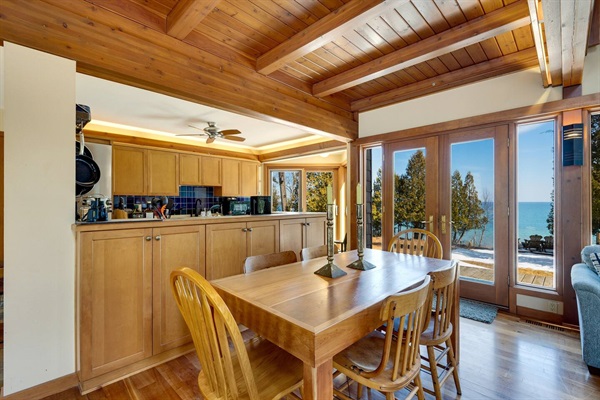 Dining to the sounds of the lake. Living room and dining room doors open to the lake side of the house.
