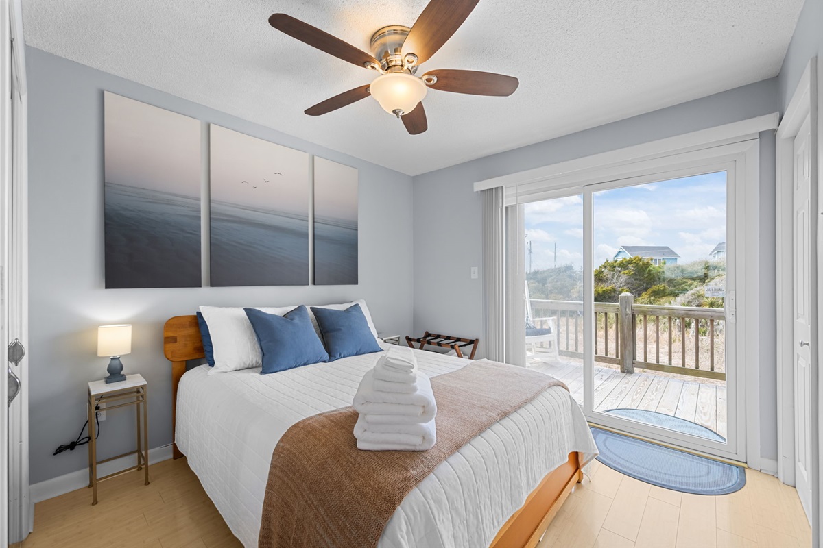 Calm, airy master bedroom with private balcony access; wake up to natural light and coastal breezes
