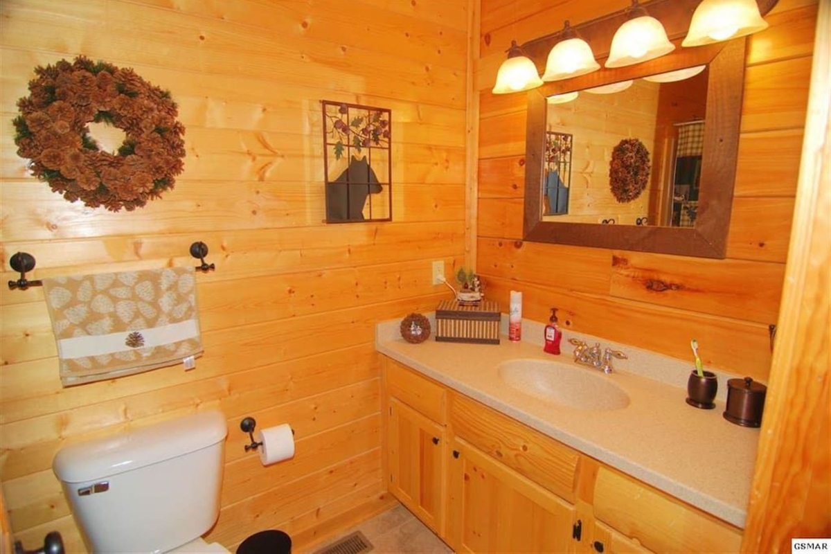 - Warm wood-paneled bathroom with soft lighting and rustic mountain decor   - Equipped with modern fixtures and thoughtful cabin-style touches   - Relaxing space for freshening up after Smoky Mountain adventures