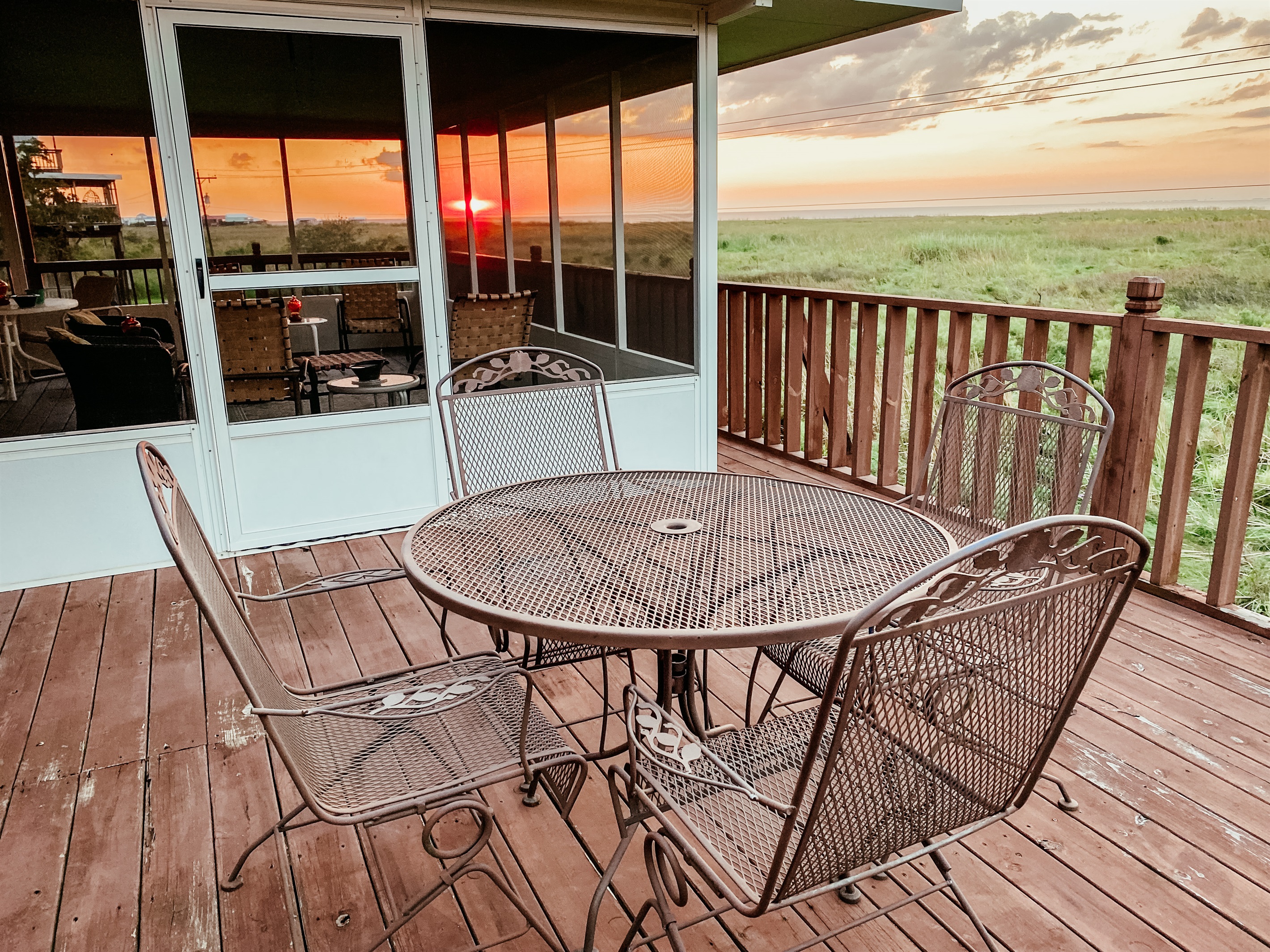 Uncovered dining with wrought iron spring chairs and amazing sunset views of cove.