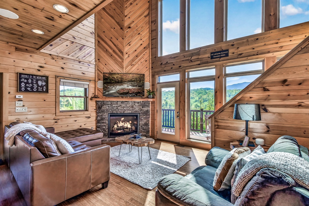 Cozy Living Room on the main level with gas Fireplace, Smart TV & Mountain Views. Stairs are required to get to the main level which is the middle or second floor