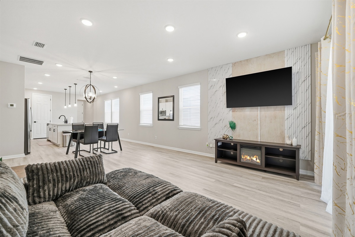 Electric fireplace sits under the huge living room TV