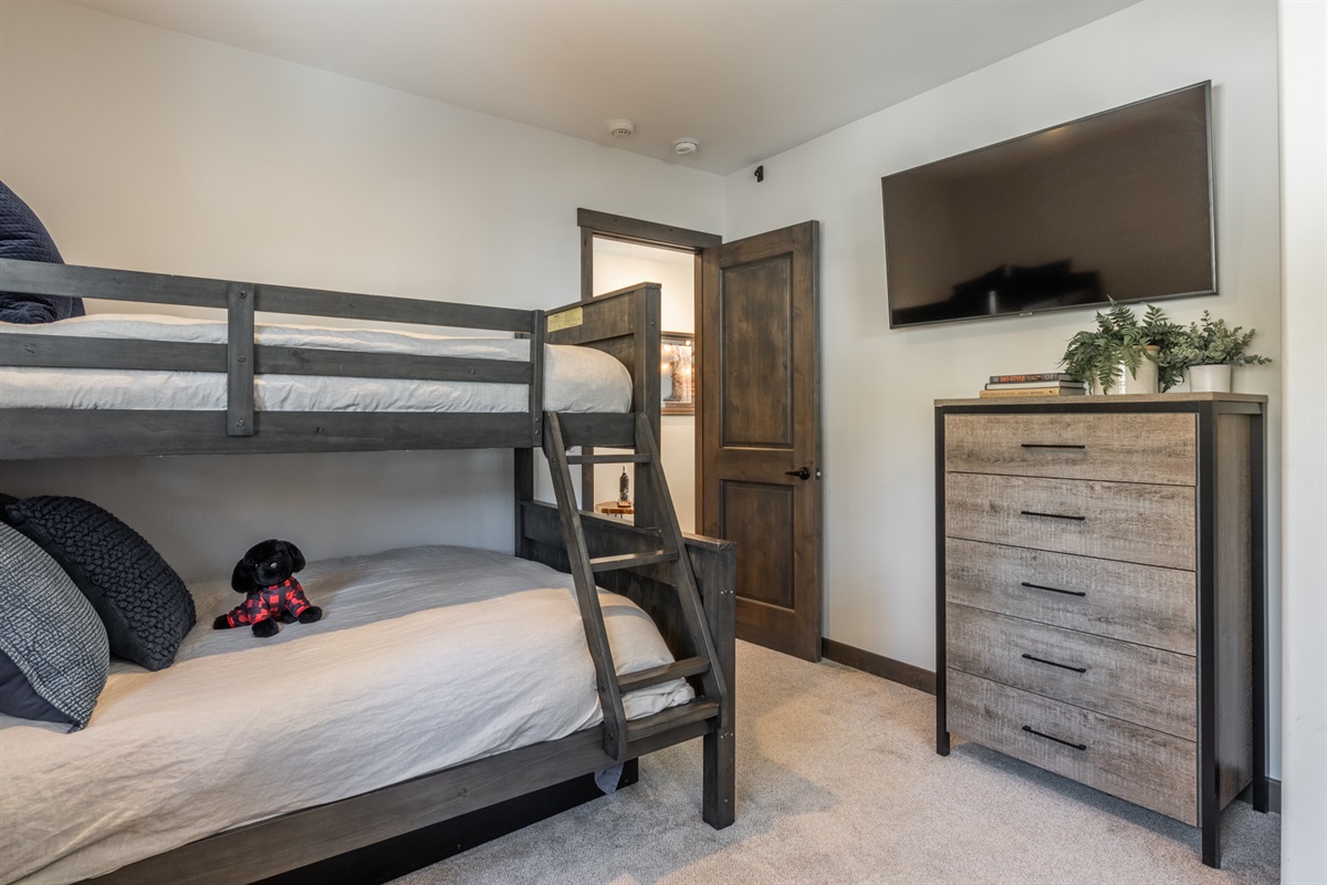 Twin-over-full bunks paired with a TV make this room a hit with kids and friends alike—perfect for movie nights, late laughs, and shared mountain memories.