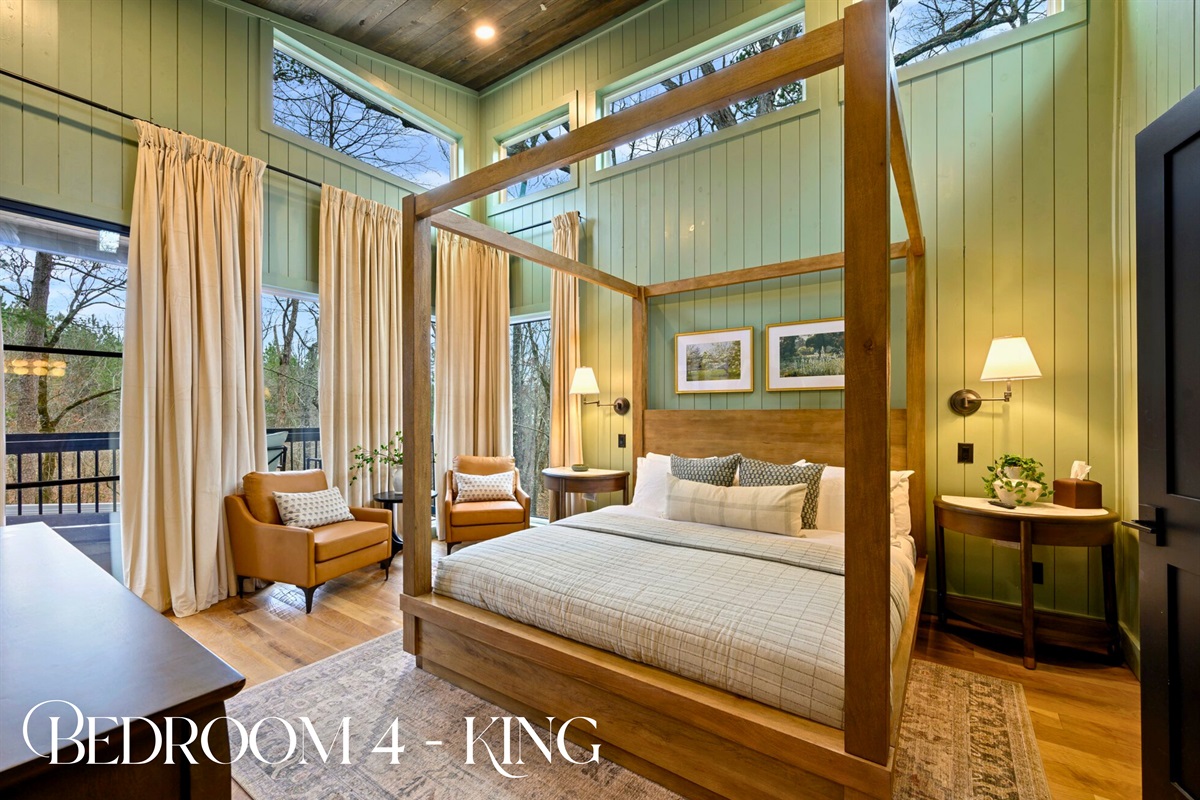 Another inviting king suite features a canopy bed, cozy lighting, and big windows that look out into the trees.